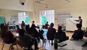 A classroom scene showing students seated and attentively listening to David Delikat - a fourth year high school math teacher at ASU Prep. David served as an implementation champion (an educator who leads the way in adopting and supporting new practices) this year for ASU Prep’s ELI-supported initiative, “Archie."
