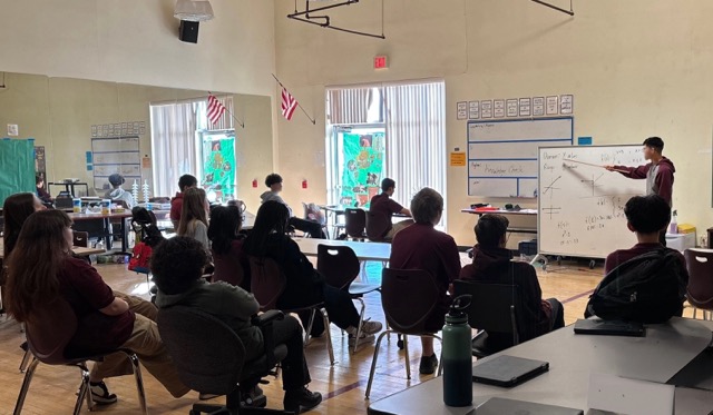 A classroom scene showing students seated and attentively listening to David Delikat - a fourth year high school math teacher at ASU Prep. David served as an implementation champion (an educator who leads the way in adopting and supporting new practices) this year for ASU Prep’s ELI-supported initiative, “Archie."