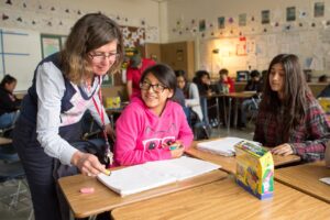 A teacher reviews a student’s work in English class.