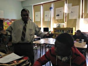 Teacher Erick Delcham discussing math concepts with a student at North Queens Community High School