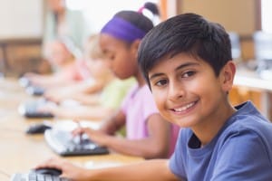 Pupils in computer class with teacher at the elementary sch