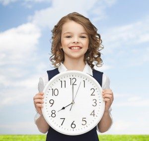 smiling girl holding clock