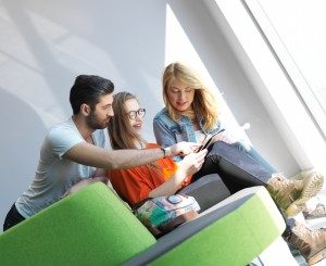 students group working on school project together on tablet computer at modern university